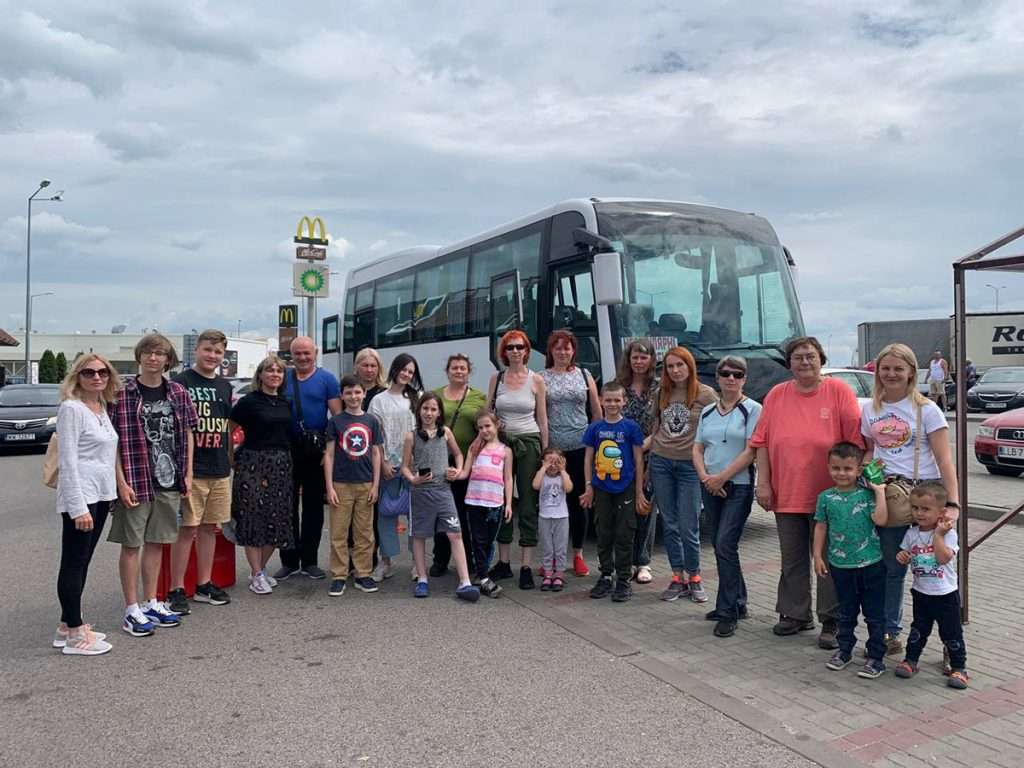 ukrainian refugees posing for a photo after getting out of a bus in ireland