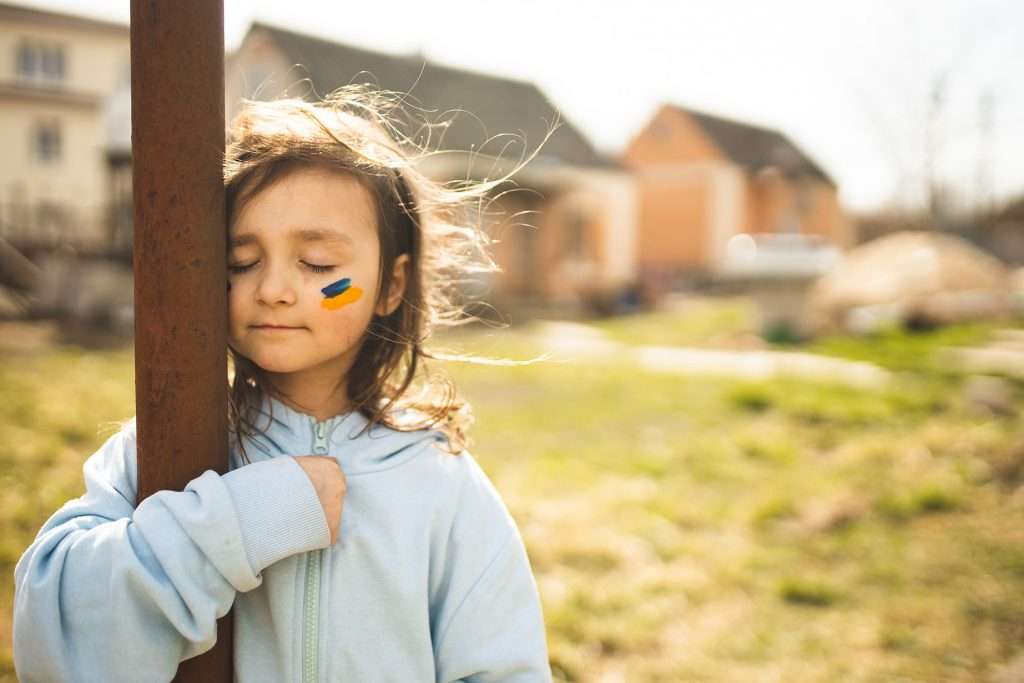 young girl with ukrainian flag face paint